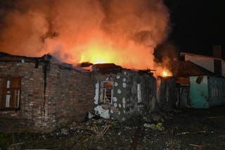 A fire in a house destroyed by a Russian drone attack in Kharkiv